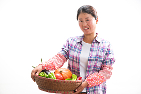 中年女人拿着一筐蔬菜