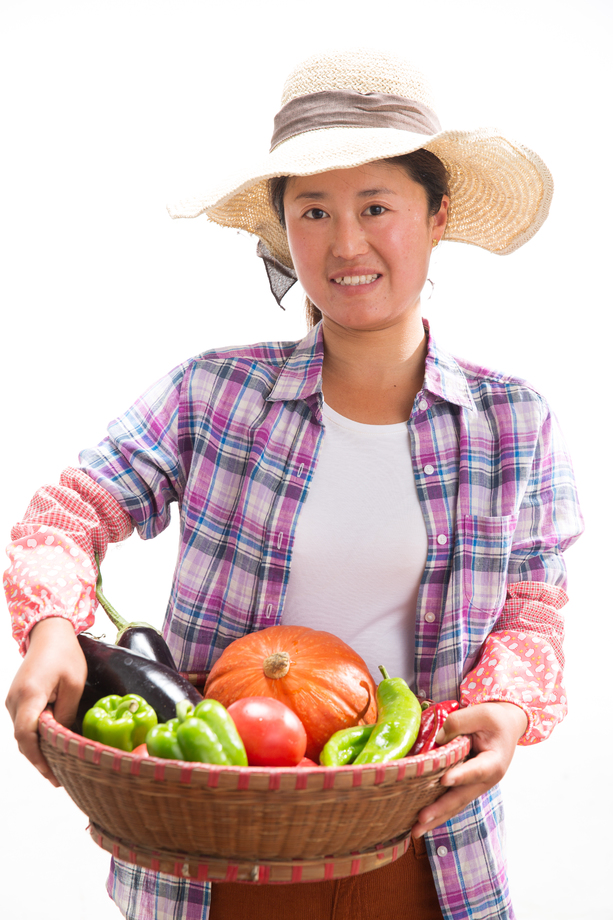 中年女人拿着一筐蔬菜图片