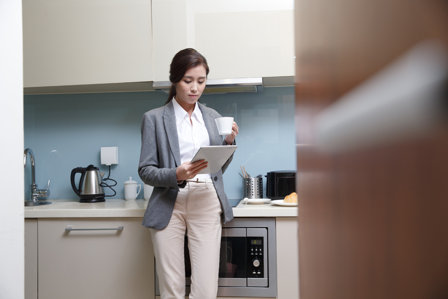 青年女人在厨房使用平板电脑 青年女人在厨房使用平板电脑