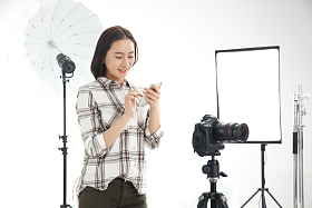 青年女摄影师拿着手机图片