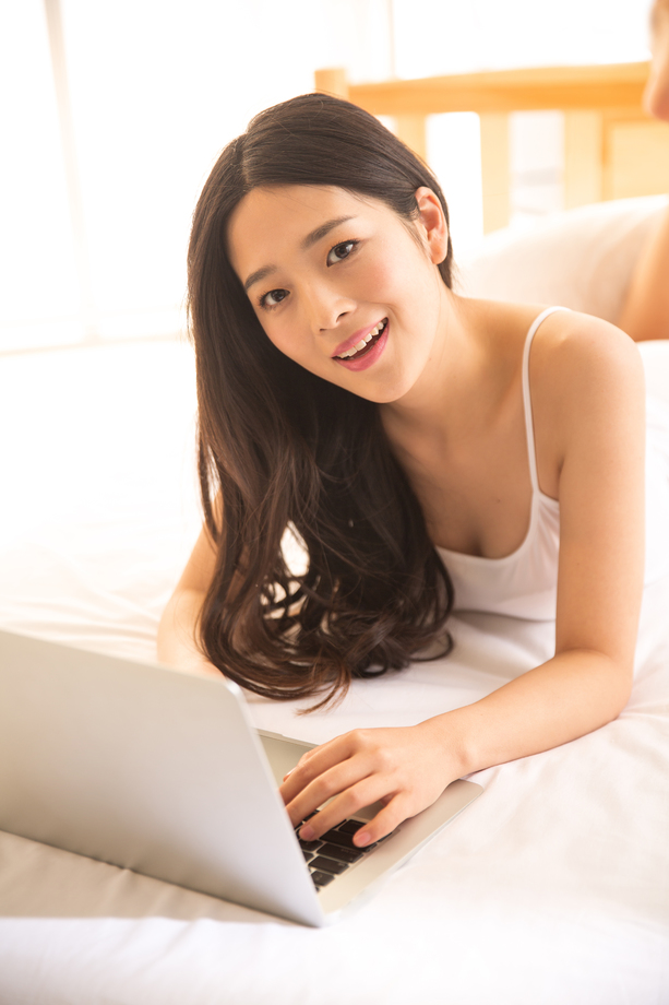青年女人在卧室使用电脑