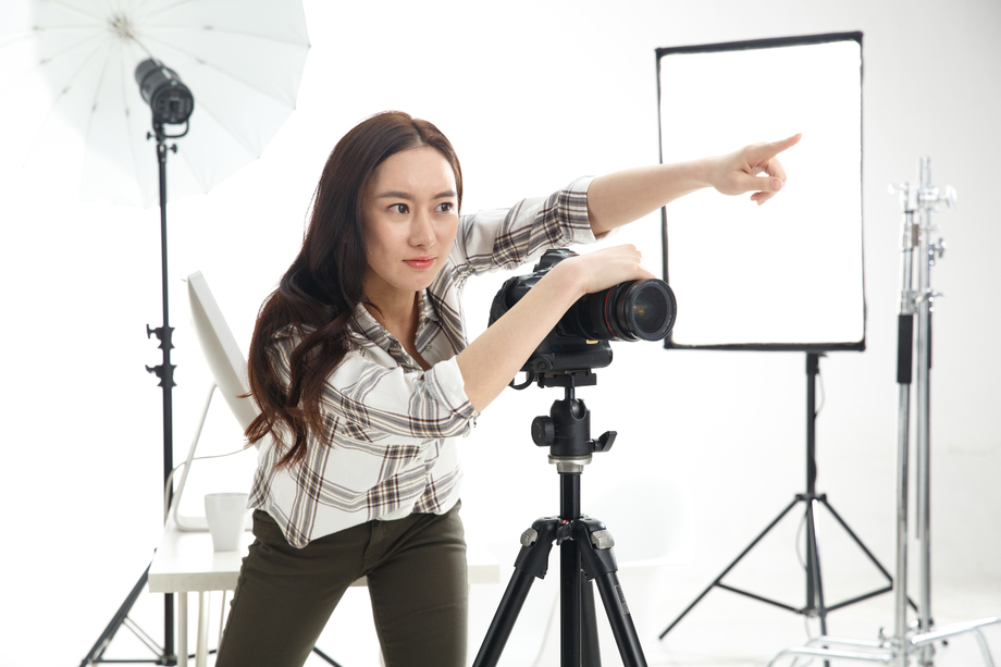 青年女摄影师拿着手机图片