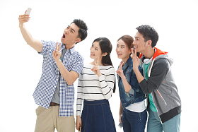 四个的大学生使用手机拍照