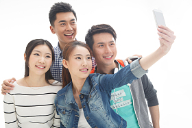 四个的大学生使用手机拍照照片