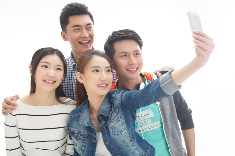 四个的大学生使用手机拍照照片