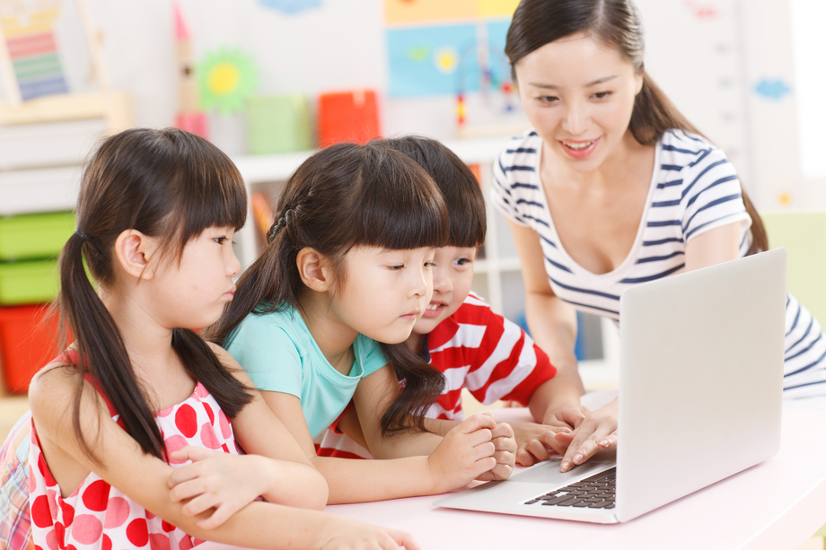 幼儿园里老师和儿童使用电脑 幼儿园里老师和儿童使用电脑
