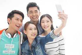 四个的大学生使用手机拍照