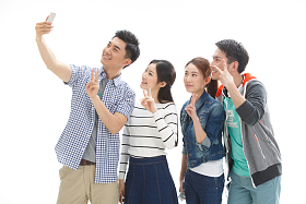 四个的大学生使用手机拍照图片