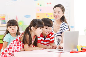 幼儿园里老师和儿童使用电脑图片