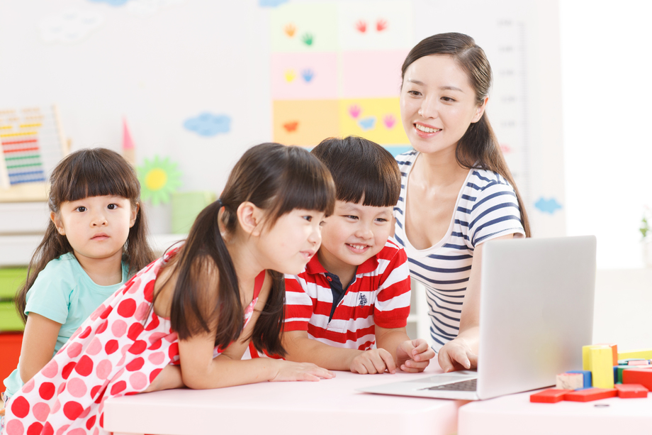 幼儿园里老师和儿童使用电脑图片
