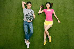 青年情侣躺在草地上玩耍图片