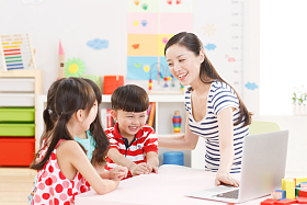 幼儿园里老师和儿童使用电脑