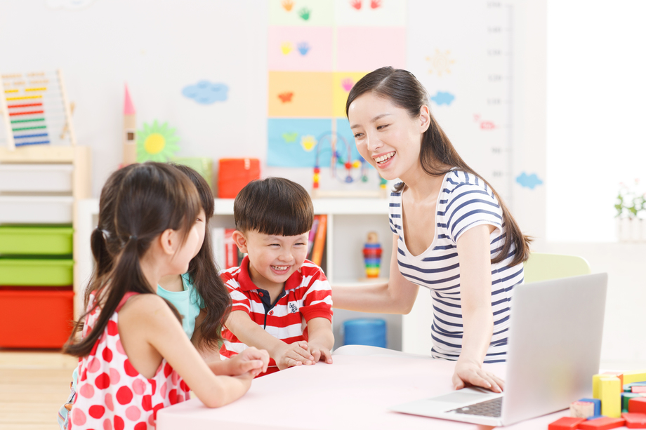 幼儿园里老师和儿童使用电脑