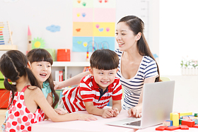 幼儿园里老师和儿童使用电脑照片