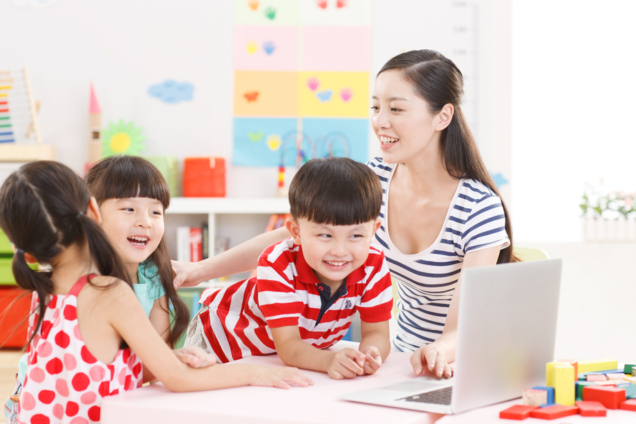幼儿园里老师和儿童使用电脑照片