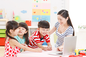幼儿园里老师和儿童使用电脑图片