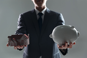 手拿存钱罐及房屋模型