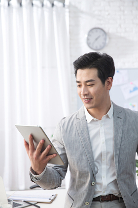 青年商务男人拿着平板电脑办公