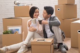 年轻夫妇坐在地板上喝水