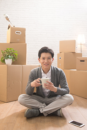 青年男人坐在地板上喝水