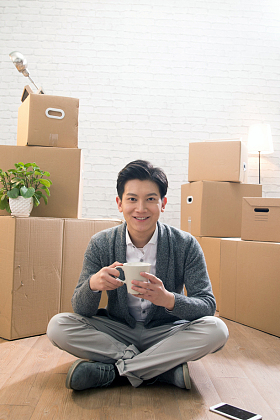 青年男人坐在地板上喝水照片