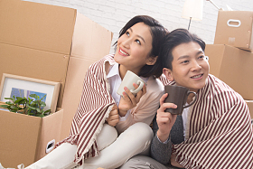 年轻夫妇坐在地板上喝水