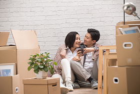 年轻夫妇坐在地板上喝水