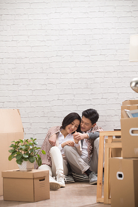 年轻夫妇坐在地板上喝水