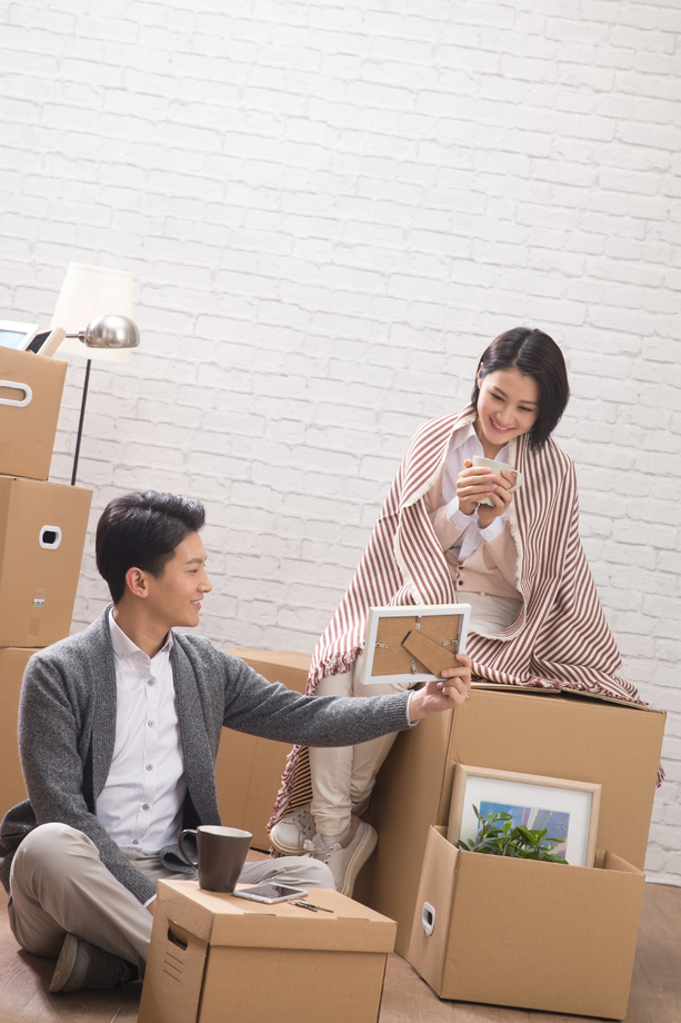 年轻夫妇坐在地板上喝水