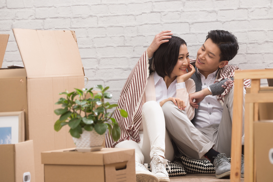 年轻夫妇坐在地板上喝水 年轻夫妇坐在地板上喝水