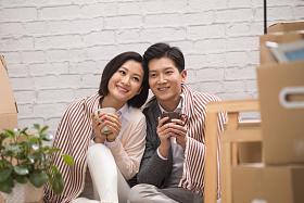 年轻夫妇坐在地板上喝水