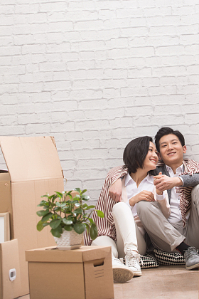 年轻夫妇坐在地板上喝水