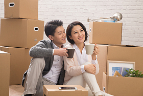 年轻夫妇坐在地板上喝水