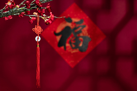 悬挂在梅花下面的中国结照片