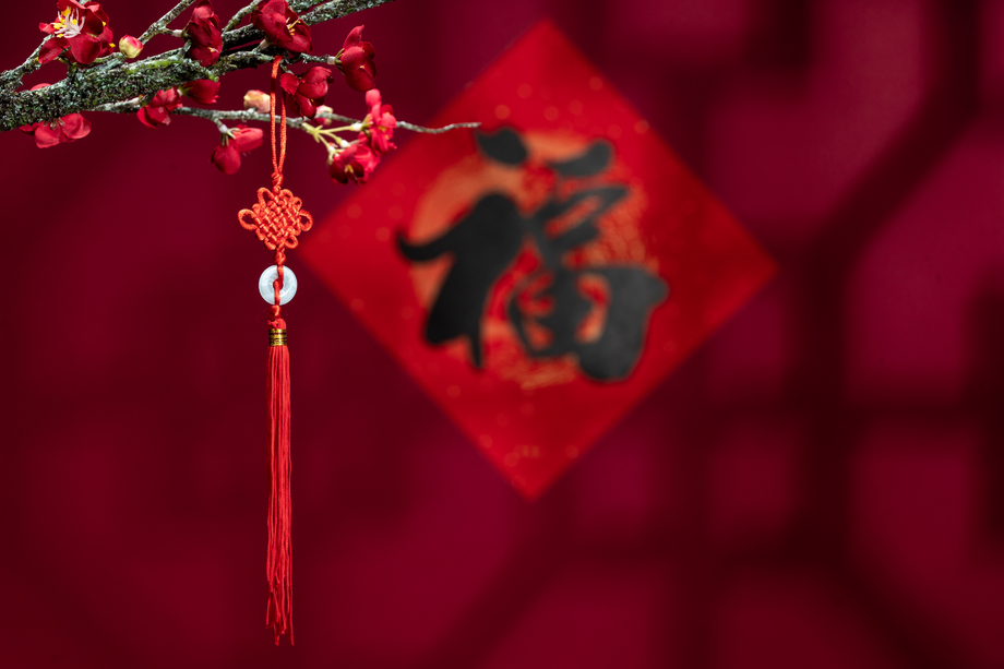 悬挂在梅花下面的中国结照片