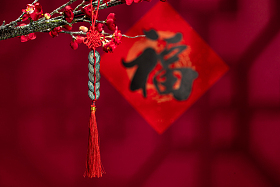 悬挂在梅花下面的中国结图片