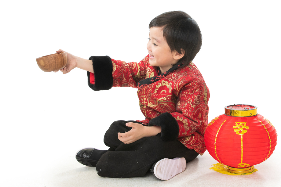 小男孩过年穿新衣服盘腿坐地上
