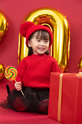 小女孩过年穿新衣服手拿棒棒糖