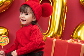 小女孩过年穿新衣服手拿棒棒糖