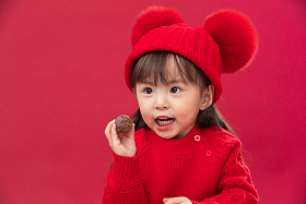 小女孩过年穿新衣服手拿巧克力