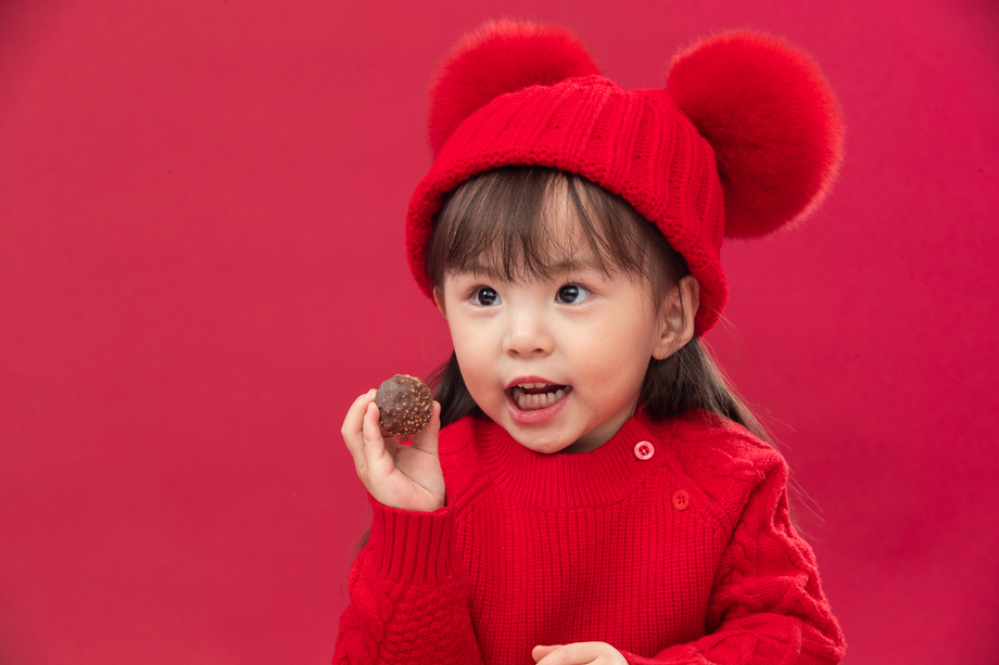 小女孩过年穿新衣服手拿巧克力 小女孩过年穿新衣服手拿巧克力