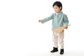 小男孩拿着簸箕撒谷物照片