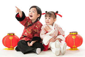 兄妹两人穿新衣服坐在地上庆祝新年