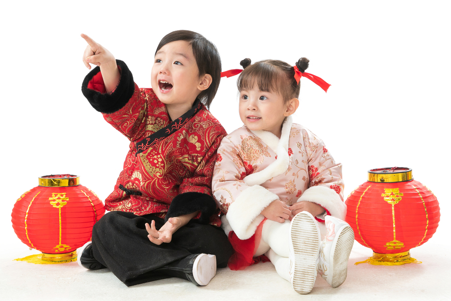 兄妹两人穿新衣服坐在地上庆祝新年