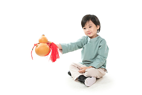 小男孩拿着葫芦盘腿坐地上