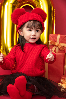 小女孩过年穿新衣服手拿棒棒糖