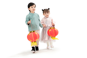 两个小朋友手牵手拿着红灯