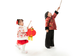 过新年的两个小朋友拿着红灯