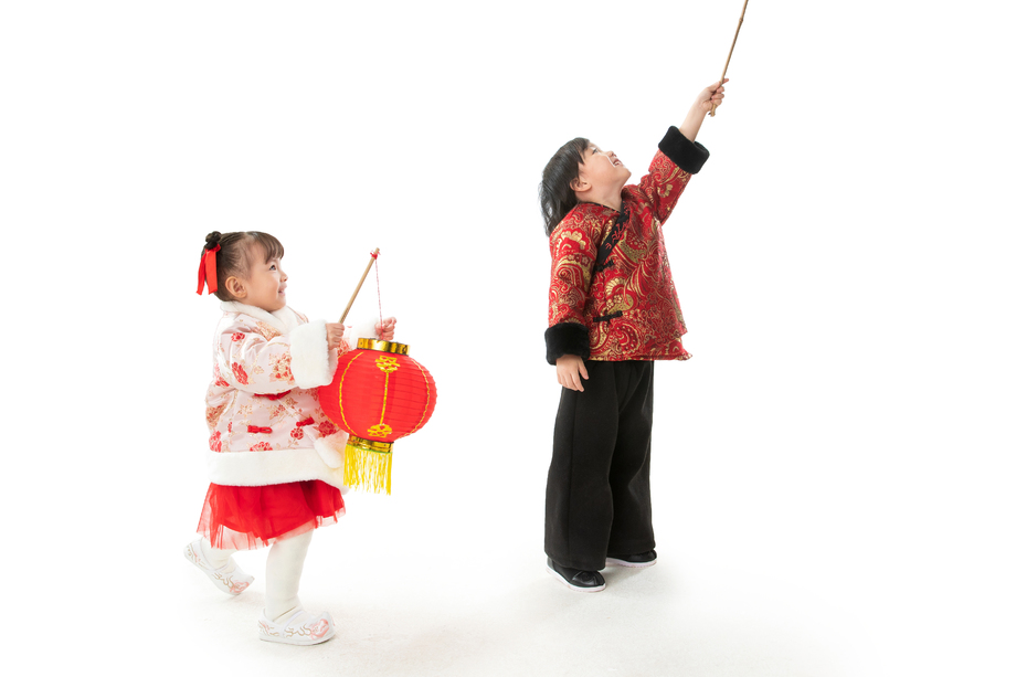 过新年的两个小朋友拿着红灯