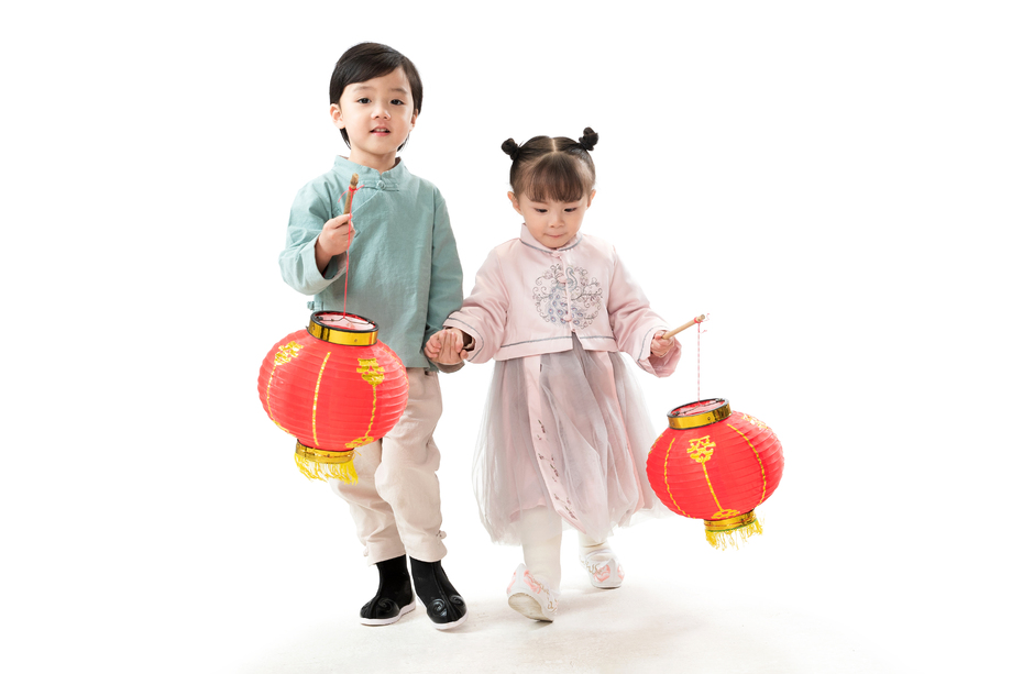 两个小朋友手牵手拿着红灯